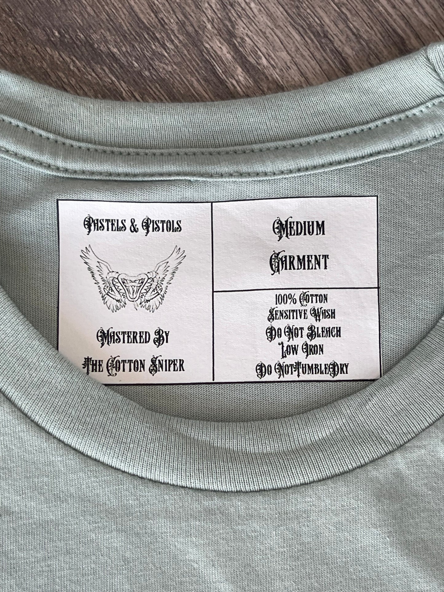 Pastels & Pistols custom neck tag on the “Say Less” seafoam green rhinestone tee.