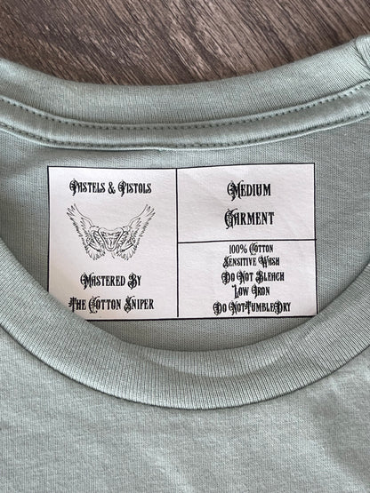 Pastels & Pistols custom neck tag on the “Say Less” seafoam green rhinestone tee.